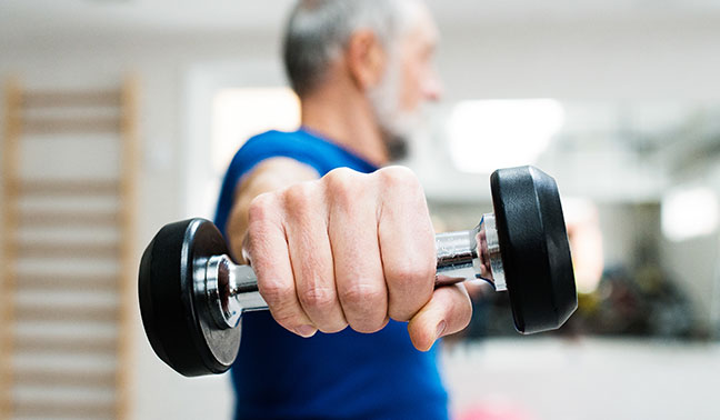 close up on hand of senior man holding weight