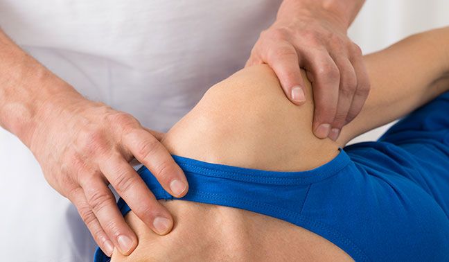 physiotherapist does manual therapy on shoulder