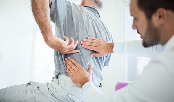 a physiotherapist addressing back pain with a patient