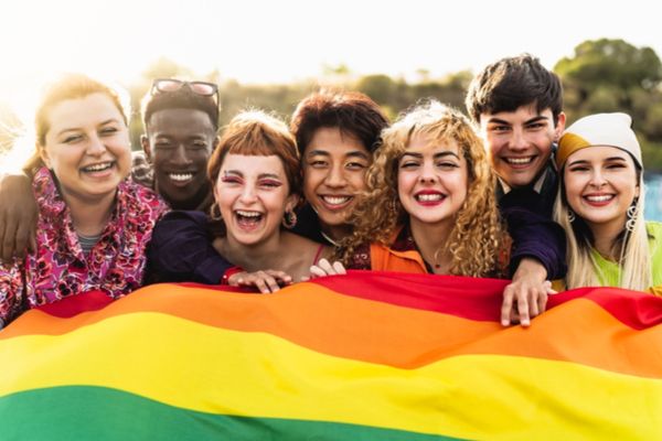 A group of friends outside holding pride flag