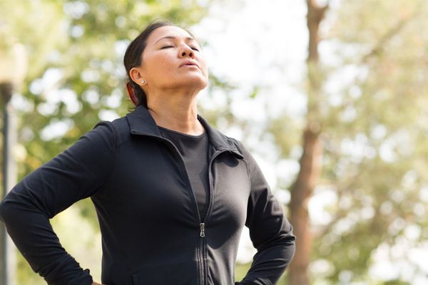 A woman deep breathing outside