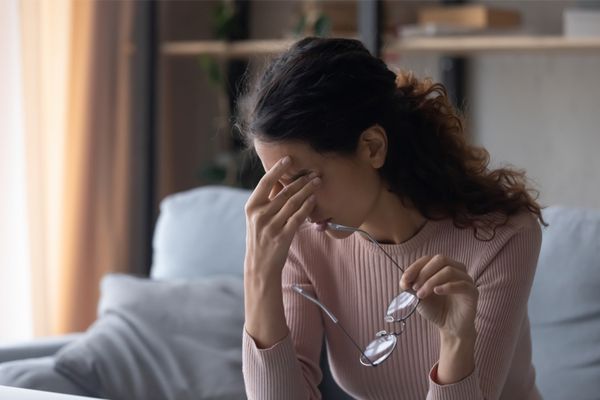 a stressed woman rubbing her eyes