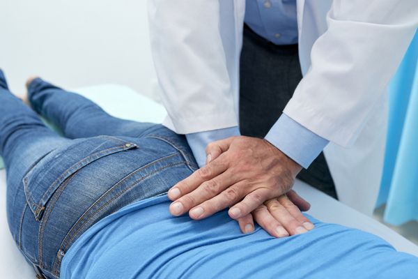 Chiropractor doing pushing motion to adjust back