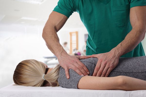 A woman having a chiropractic back adjustment