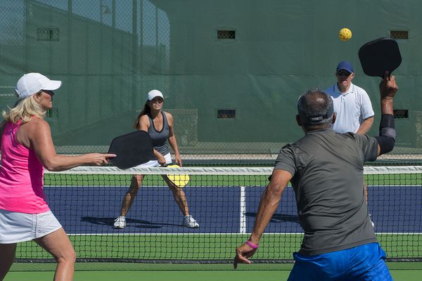 A group of adults playing racquet ball 