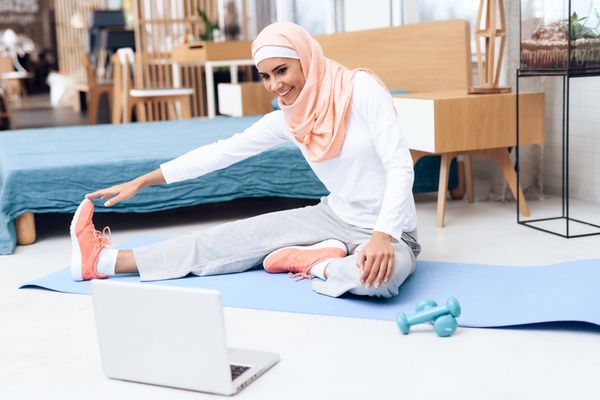 a woman doing exercises on a mat at home 