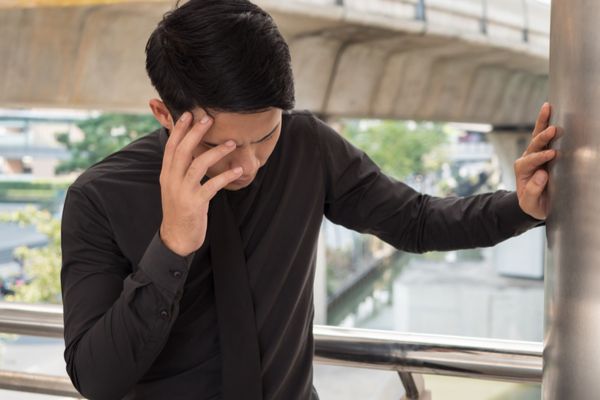 a man holding a wall because he is dizzy