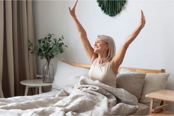 an elderly woman waking up, feeling refreshed 