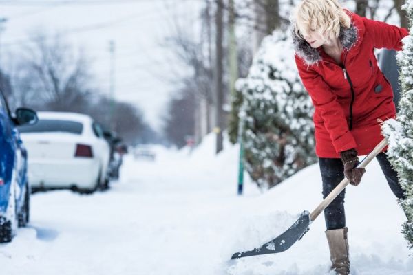 a woman shovelling snow 