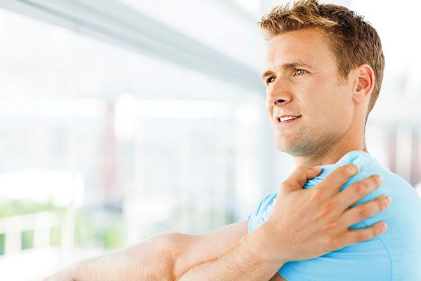 Man holding a sore shoulder