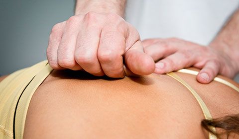 therapist using myofascial release techniques on patients back