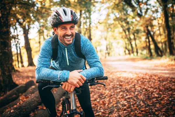 Cycling movements for post-cycling bliss Happy man in blue cycling in autumn