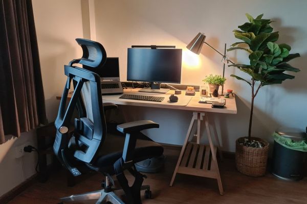 Ergonomic chair, table and monitor set up. With lamp and plant.