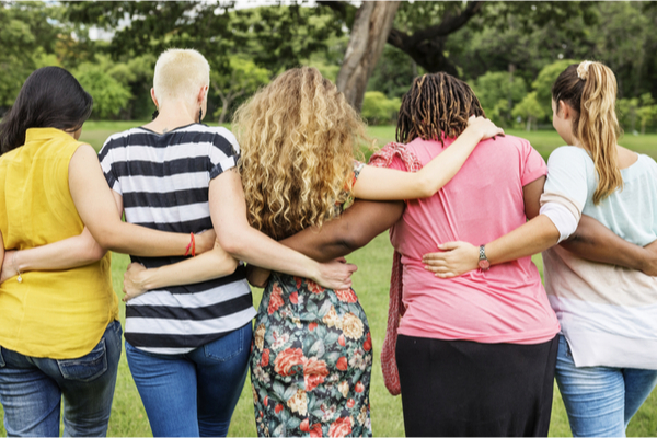 A group of women embracing each other in a park