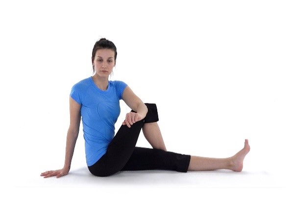 a woman doing a seated IT band glute stretch