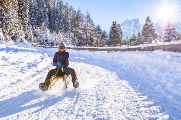 a woman tobogganing in the winter 