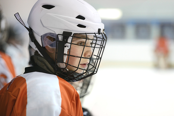 kid playing hockey and sitting on the bench