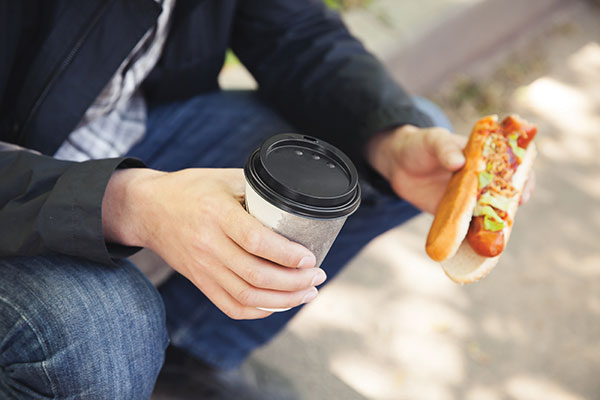 Man with coffee and hotdog
