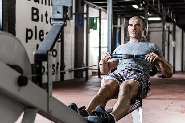 man on rowing machine at gym