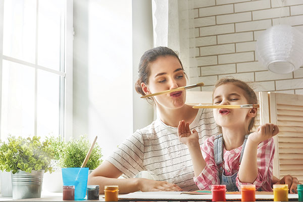 Mother and daughter having fun while painting