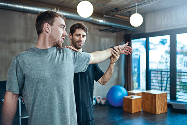 man getting his shoulder assessed by a physiotherapist