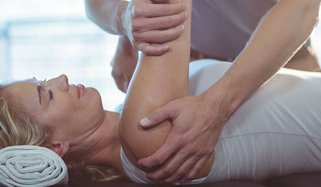 physiotherapist performing manual therapy on patients shoulder