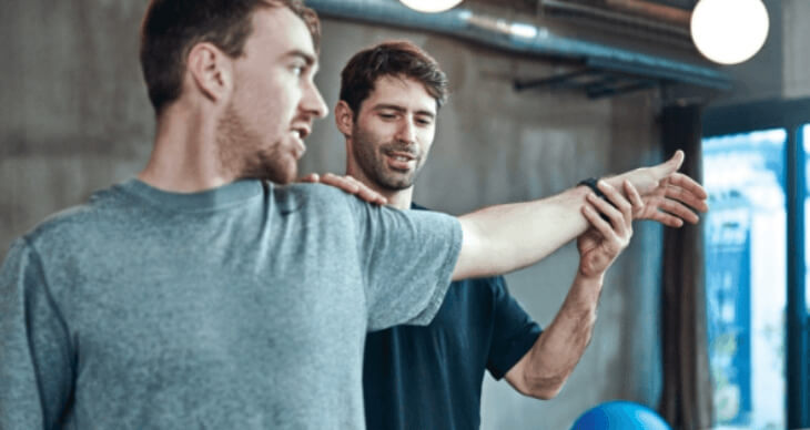 Physiotherapist doing stretching exercises with man