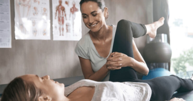 Physiotherapist performing leg exercises