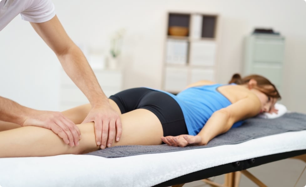 ART - Woman on a bed with a therapist working on her thigh