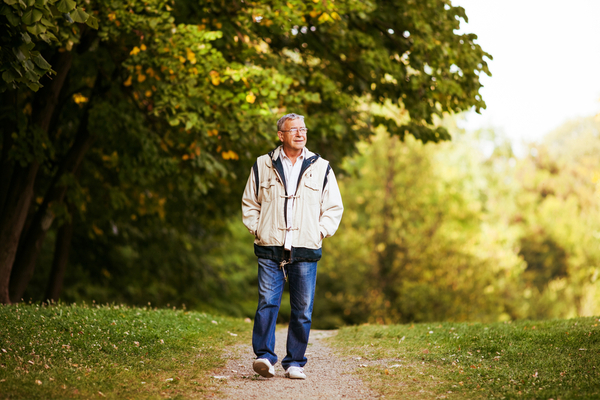 an elderly man walking in a park