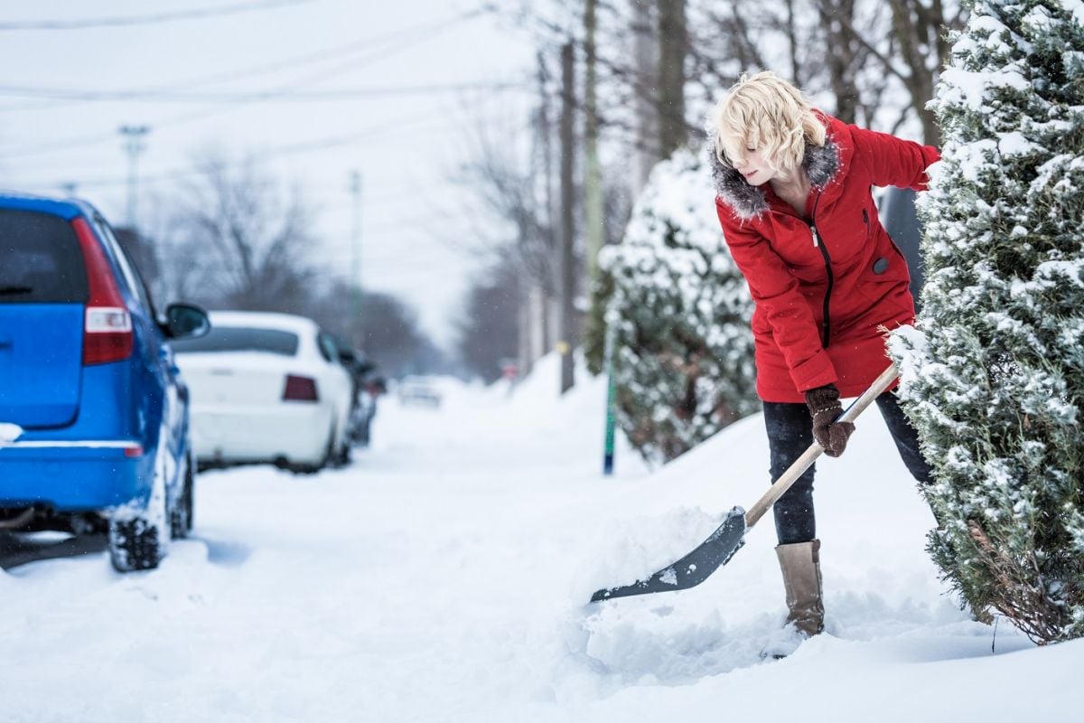 a woman shovelling snow 