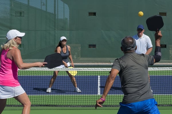 A group of adults playing racquet ball