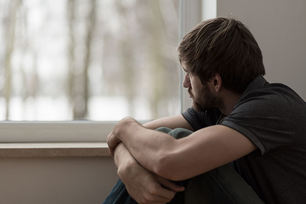 Man looking sad at a window Man looking sad at a window