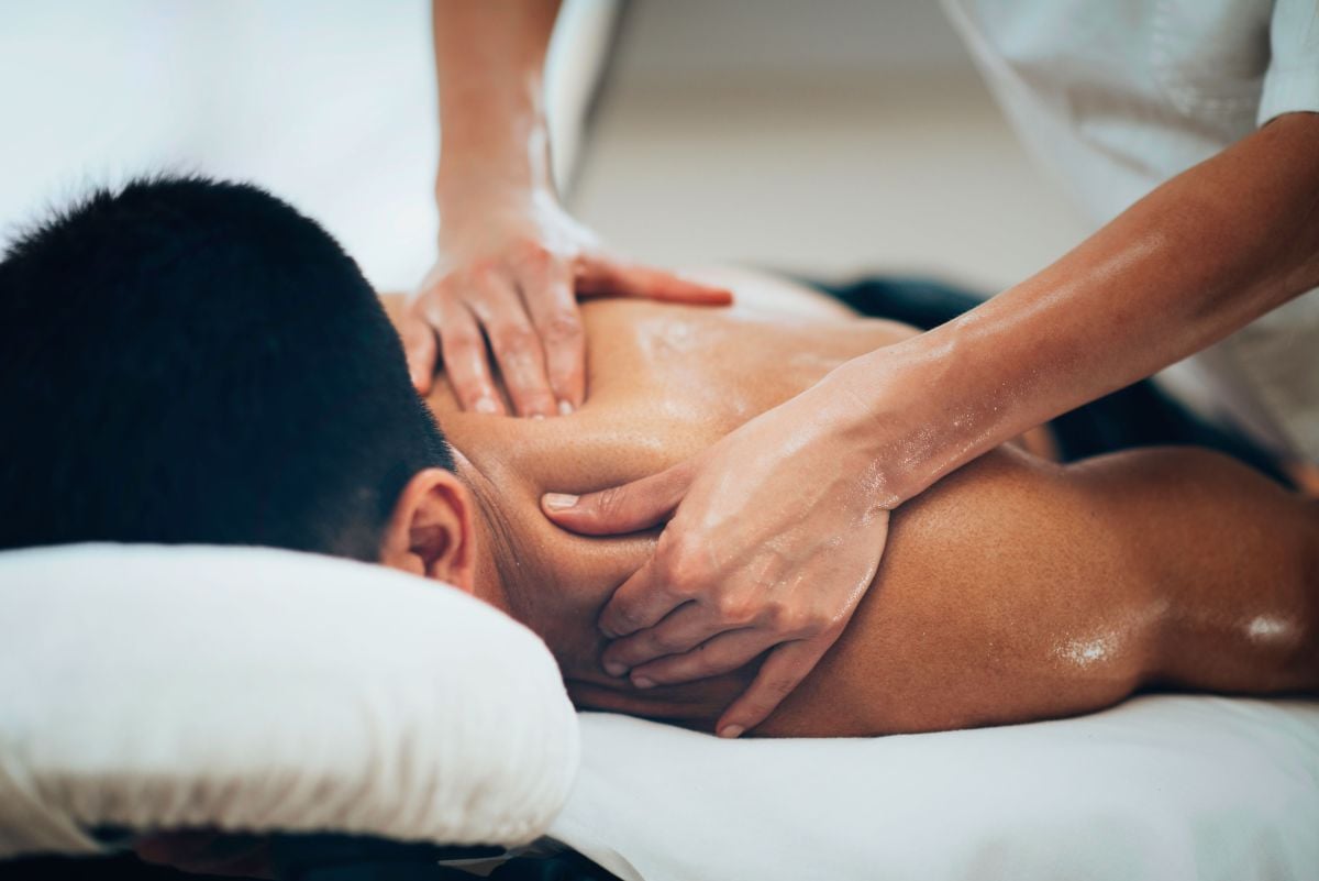 Man receiving massage to neck and shoulder