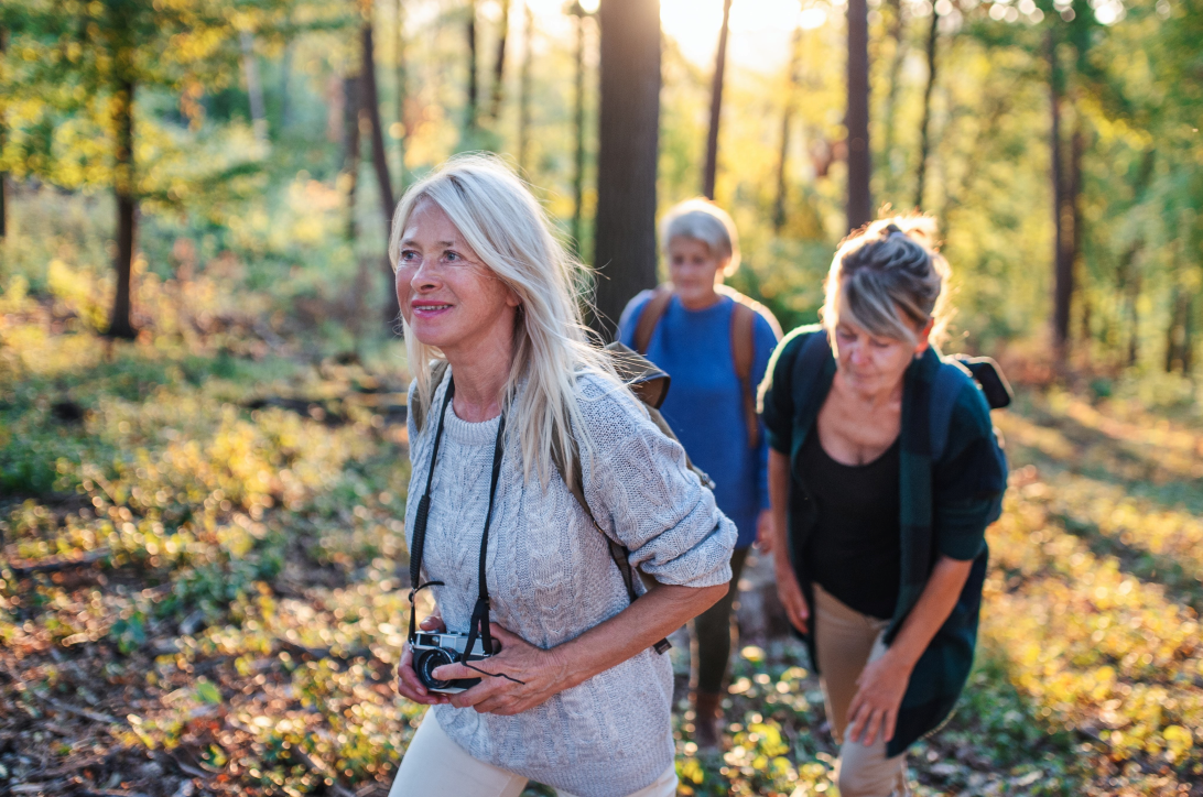 3 middle aged women hiking comfortably and happily