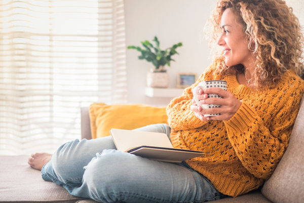 A woman enjoying a cup of coffee and a book