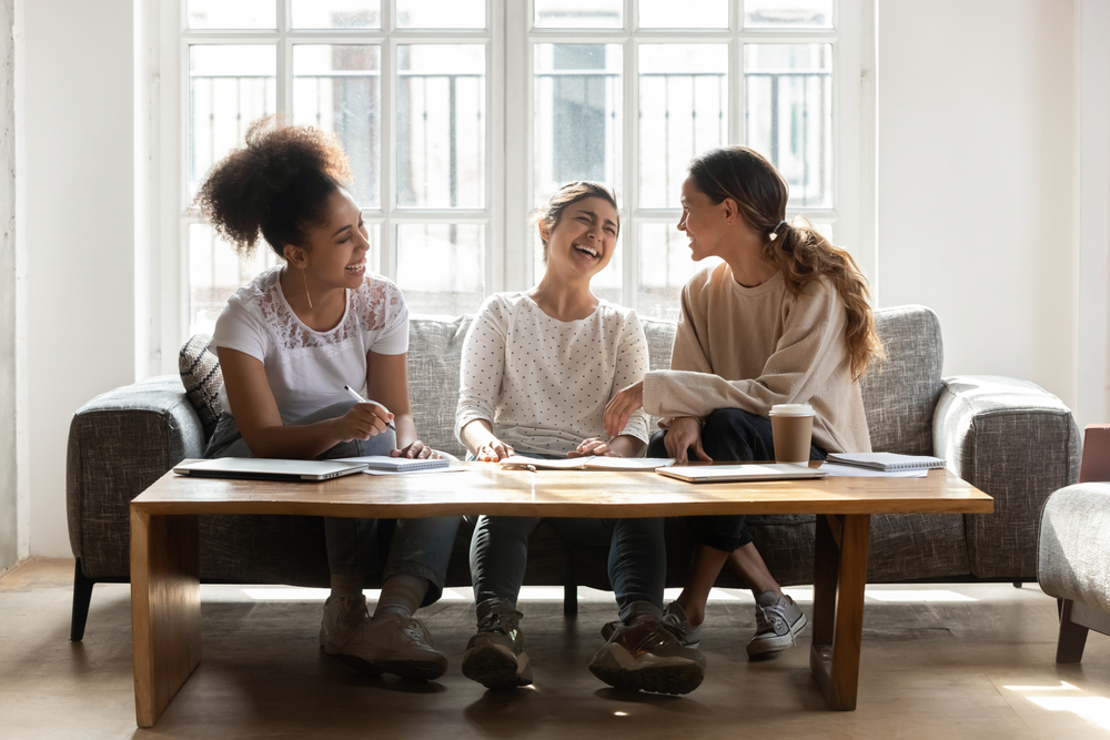 3 women laughing on couch