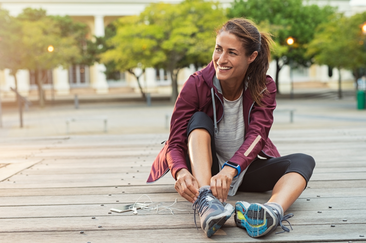 Female fitness runner getting ready for jogging outdoors in spring.