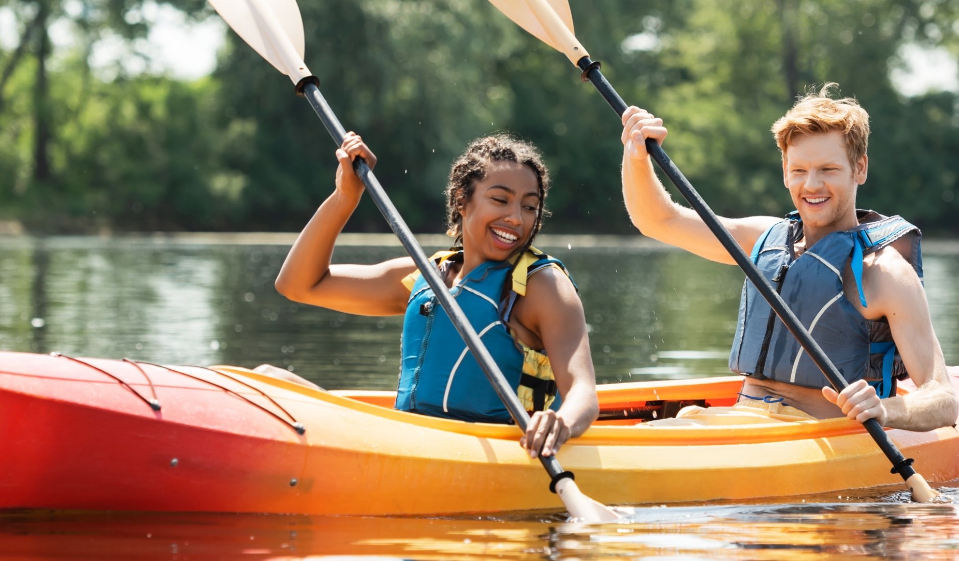 A young couple is enjoying kayaking together during the summer