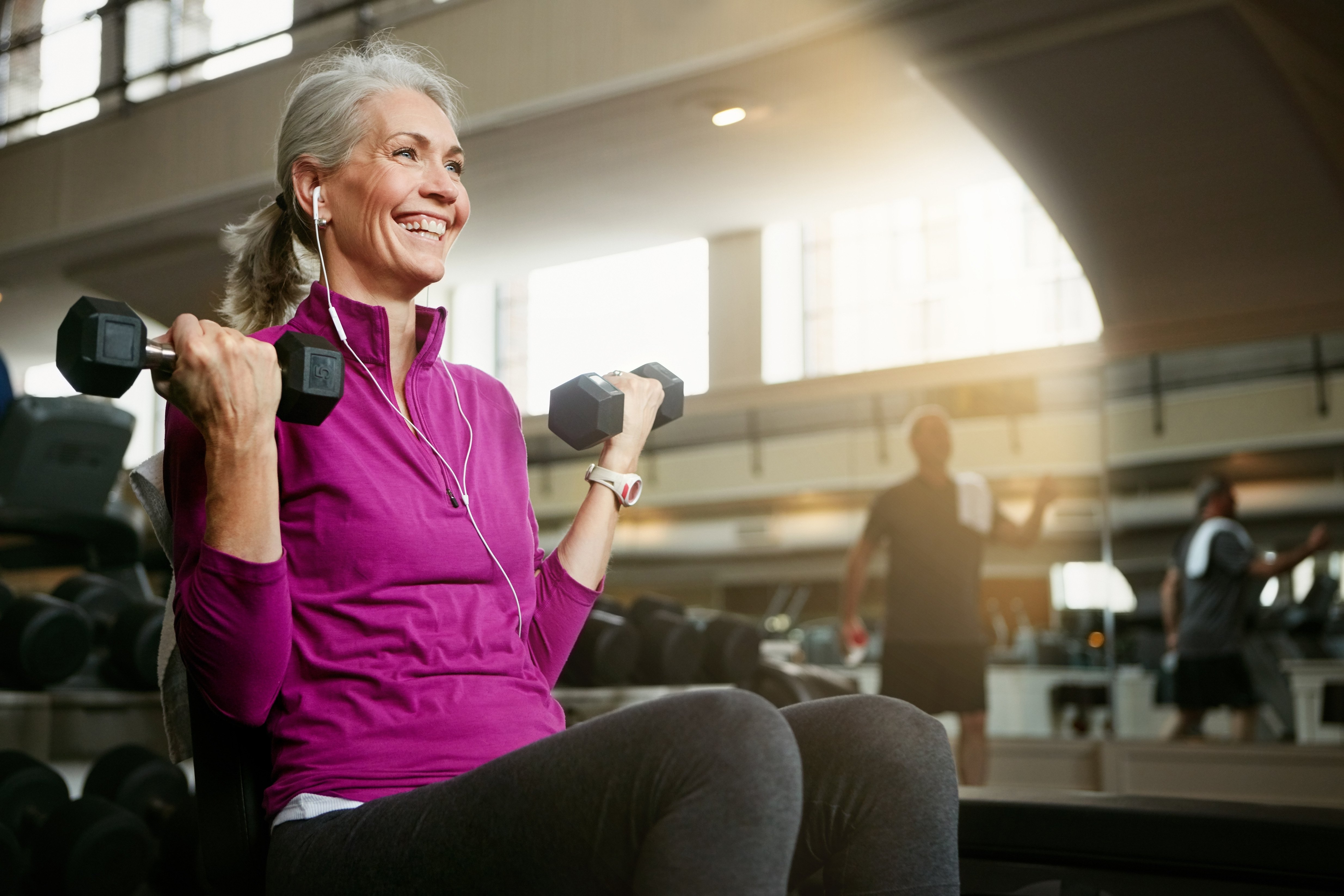 Senior woman lifting dumbbell at the gym
