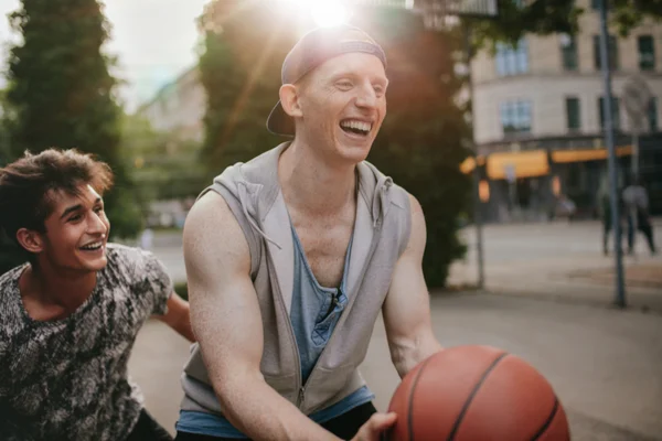 Young men playing basket ball outside