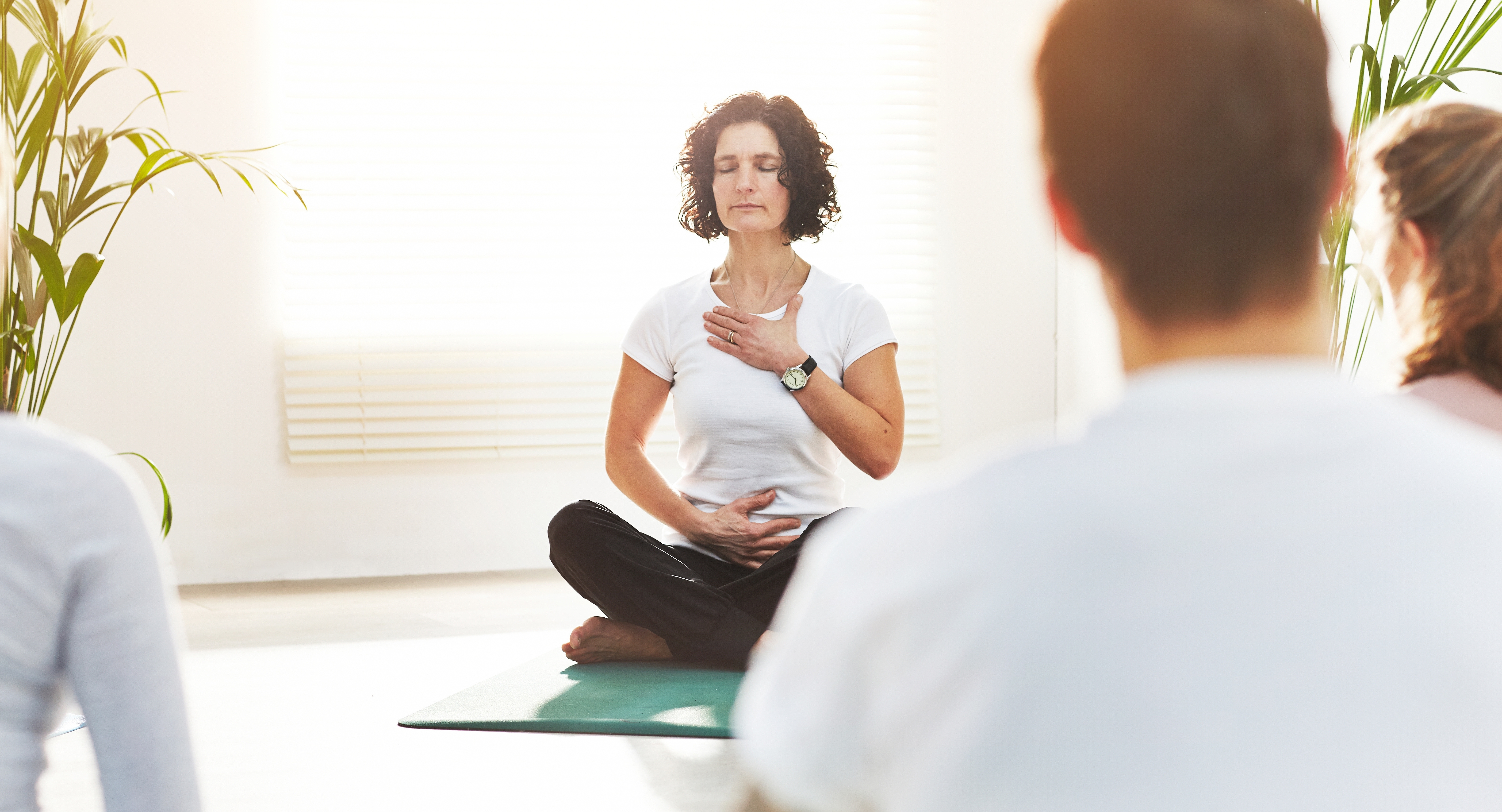 Woman doing breathwork exercises in a mindfulness yoga class