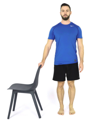 Person standing beside a chair before a single-leg balance test