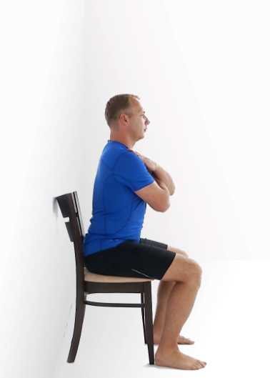 Person seated in a chair with arms crossed