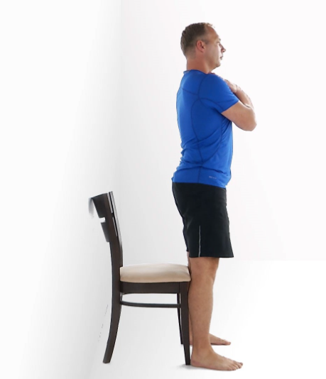 Person standing from a chair with arms crossed