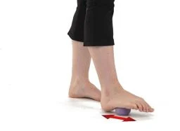 Rolling the bottom of foot with a ball for plantar fasciitis