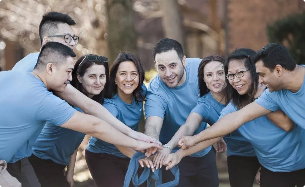 A Lifemark team huddle putting their hands in
