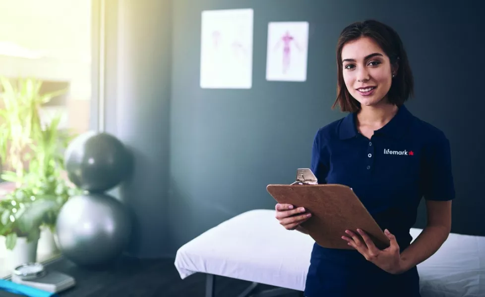 A woman in a blue lifemark shirt holding a clipboard