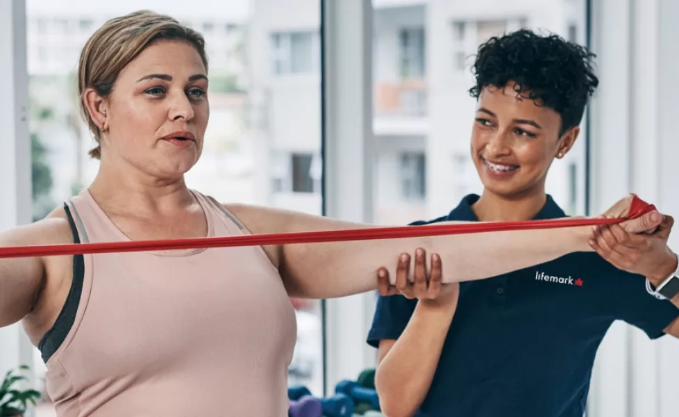 Therapist with patient using a red arm band
