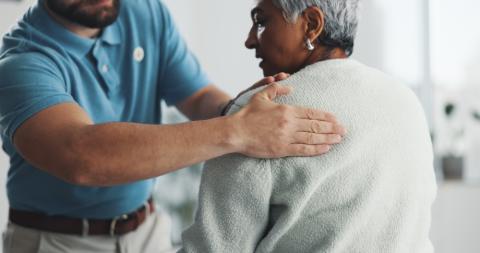 Woman with shoulder frozen shoulder and stiffness receiving physiotherapy treatment